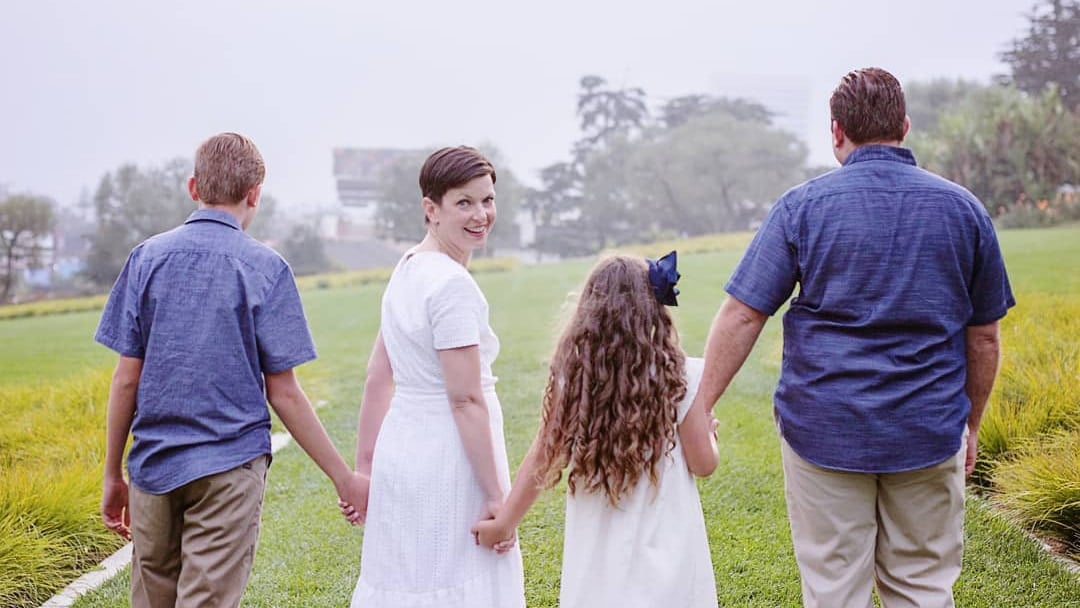 Jaime, smiling, looking back at us, as her family walks forward